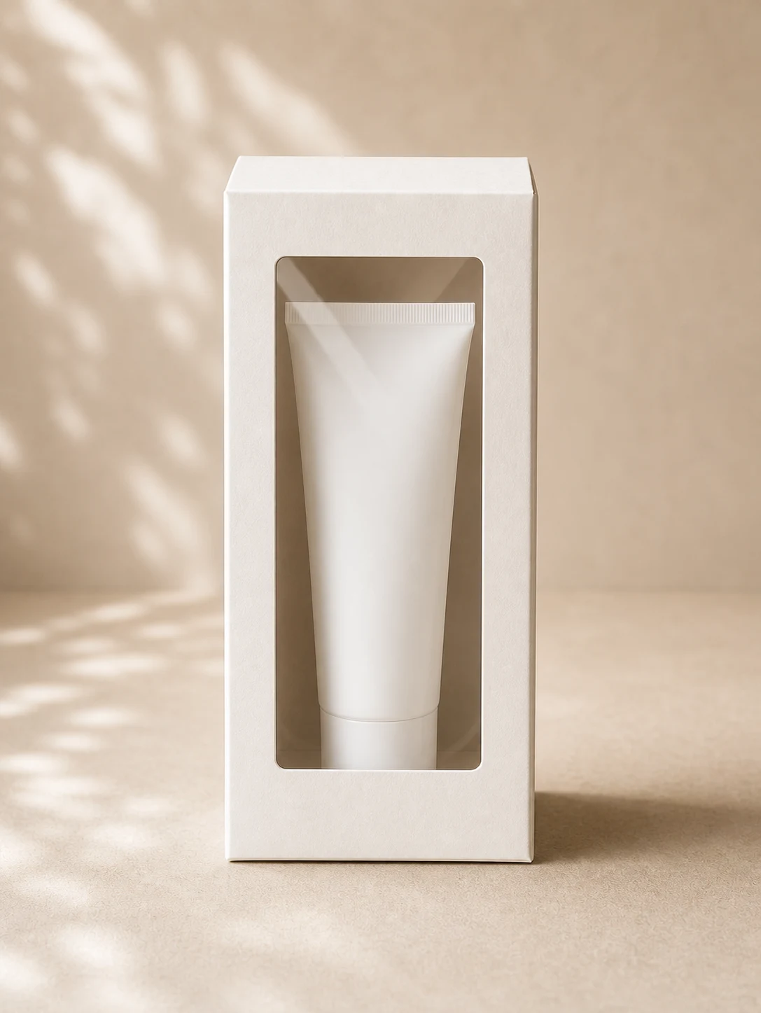 Front view folding carton with window frame and clear film showing an unbranded skincare tube